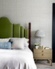 Bedroom interior by Crave Interiors featuring a velvet green headboard, dark wood furniture, and Birch Raffia Wallpaper in Slate by Kate Blee — a rich layering of natural textures and muted tones.